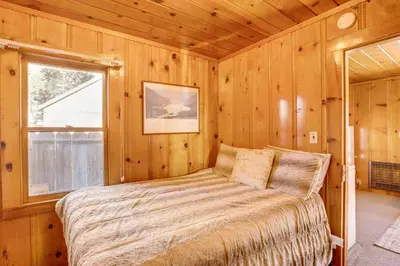 a bedroom with a bed in a wooden cabin at Close to Lake and Heavenly Mtn Resort! Quaint Cabin in South Lake Tahoe