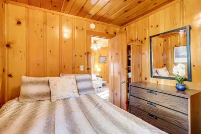 a bedroom with a bed with a dresser and a mirror at Close to Lake and Heavenly Mtn Resort! Quaint Cabin in South Lake Tahoe