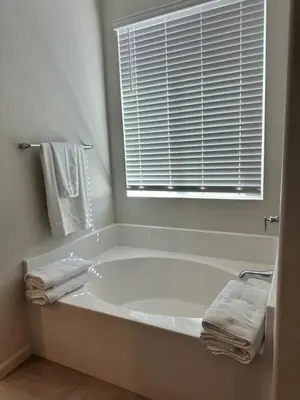 a white bath tub in a bathroom with a window at Prime Location Residence in Manteca
