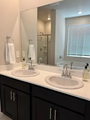 a bathroom with two sinks and a large mirror at Prime Location Residence in Manteca
