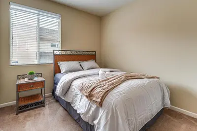 a bedroom with a bed with a nightstand and a window at Sophisticated Sanctuary 8 Mi to Lodi Wineries! in Stockton