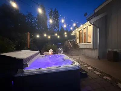 a hot tub in a backyard at night with lights at Vista Chalet near Yosemite and Bass Lake in Oakhurst