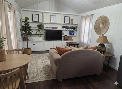 a living room with a couch and a tv at La Lomas Bohemian Courtyard Cottage in Modesto
