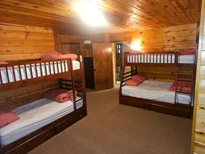 a room with three bunk beds in a cabin at Peaceful Mountain Cabin with Private Lake and Game Room Near Long Barn, California in Long Barn