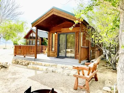 a log cabin with a porch and a bench at Cozy Mountain-Style Cabin with Scenic Sierra Nevada Views Near Lone Pine, California in Lone Pine