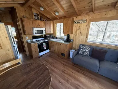 a living room with a couch and a kitchen at Cozy Mountain-Style Cabin with Scenic Sierra Nevada Views Near Lone Pine, California in Lone Pine