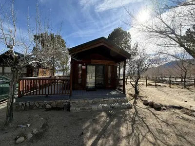 a small cabin with a porch in a field at Cozy Mountain-Style Cabin with Scenic Sierra Nevada Views Near Lone Pine, California in Lone Pine
