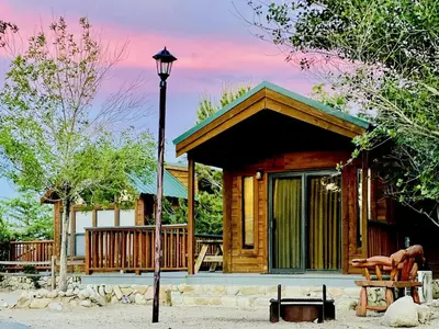 a log cabin with a porch and a street light at Cozy Mountain-Style Cabin with Scenic Sierra Nevada Views Near Lone Pine, California in Lone Pine