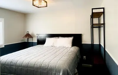 a bedroom with a bed with a black headboard at Modern Tiny Home with Mountain Views Near Mt. Whitney, Lone Pine, California in Lone Pine