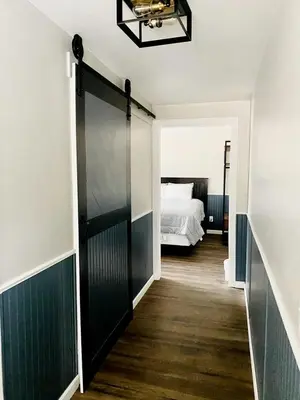 a bedroom with a bed and a door leading to a hallway at Modern Tiny Home with Mountain Views Near Mt. Whitney, Lone Pine, California in Lone Pine