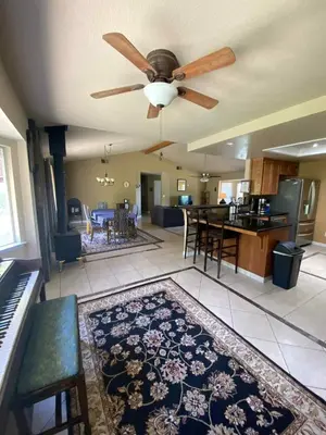 a living room with a ceiling fan and a dining room at St Annas House in Squaw Valley