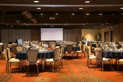 a conference room with tables and chairs and a screen at Carson Valley Inn in Minden