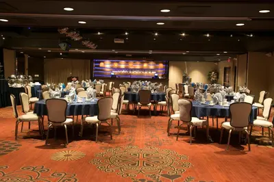 a conference room with tables and chairs and a screen at Carson Valley Inn in Minden