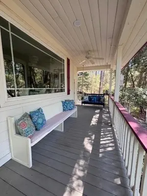 a porch with two benches on a house at The Firehouse Inn-Cottage in Mariposa