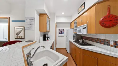 a kitchen with a sink and a red clock at The Ridgeline by AvantStay Shared Pool Hot Tub Sauna Ski-In Access Village Walk in Olympic Valley