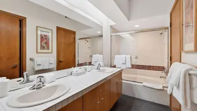 a bathroom with two sinks and a large mirror at The Ridgeline by AvantStay Shared Pool Hot Tub Sauna Ski-In Access Village Walk in Olympic Valley