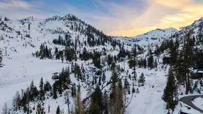 a snow covered mountain with trees and a ski lift at The Ridgeline by AvantStay Shared Pool Hot Tub Sauna Ski-In Access Village Walk in Olympic Valley