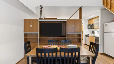 a dining room with a table with chairs and a television at The Traverse by AvantStay Ski-InSki-Out Condo • Pool Hot Tub Access • Steps to KT-22 in Olympic Valley