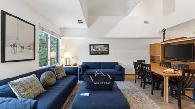 a living room with a blue couch and a tv at The Traverse by AvantStay Ski-InSki-Out Condo • Pool Hot Tub Access • Steps to KT-22 in Olympic Valley