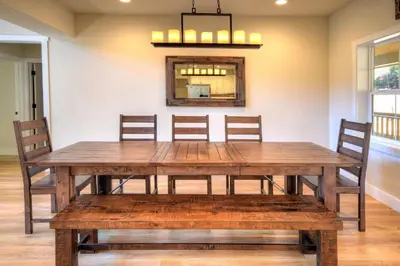 a dining room table with chairs and a mirror at River Rock Retreat in Yosemite West