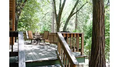 a wooden deck with a table and chairs on it at Lazy Z Resort in Twain Harte
