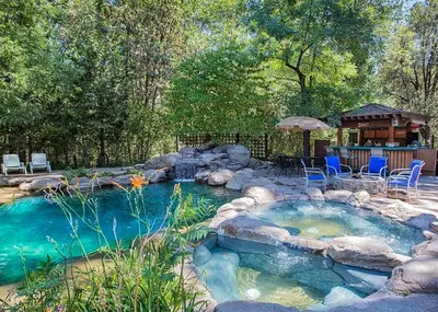 a pool of water with chairs and a gazebo at Lazy Z Resort in Twain Harte