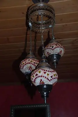 a chandelier with four lights hanging from a ceiling at Sierra Trails Inn in Mariposa