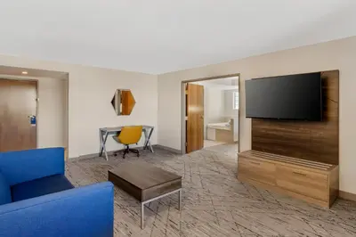 a living room with a tv and a blue couch at Holiday Inn Express Fallon by IHG in Fallon