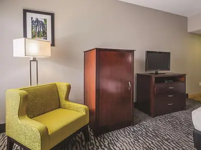 a hotel room with a chair and a tv at La Quinta by Wyndham Fresno Northwest in Fresno