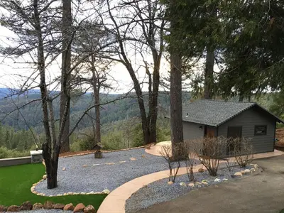 a yard with a house and trees and a driveway at Mountain Shadows Retreat in Foresthill