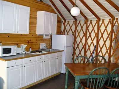 a kitchen with a white refrigerator and a table at Yosemite Lakes Hillside Yurt 1 in Harden Flat