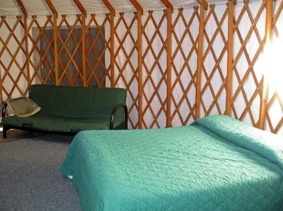 a room with a bed and a couch in a yurt at Yosemite Lakes Hillside Yurt 14 in Harden Flat