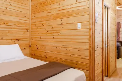 a bedroom with a bed in a wooden wall at Yosemite Lakes Cabin & Cottages in Harden Flat