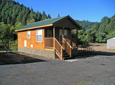 a small wooden cabin with a porch and a staircase at Yosemite Lakes Wheelchair Accessible Cabin 46 in Harden Flat