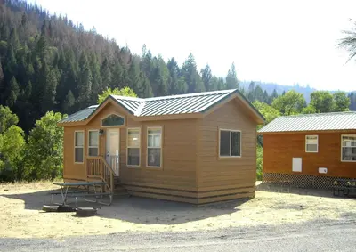 a small wooden cabin with a metal roof at Yosemite Lakes Wheelchair Accessible Cottage 53 in Harden Flat