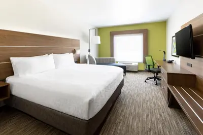 a hotel room with a bed and a television at Holiday Inn Express & Suites Oakhurst-Yosemite Park Area by IHG in Oakhurst