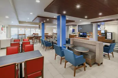a restaurant with tables and chairs and a bar at Holiday Inn Express & Suites Oakhurst-Yosemite Park Area by IHG in Oakhurst