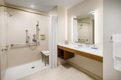 a bathroom with a tub and a sink and a shower at Holiday Inn Express & Suites Oakhurst-Yosemite Park Area by IHG in Oakhurst