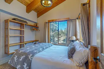 a bedroom with a bed and a large window at Village Treehouse #2 in Mammoth Lakes