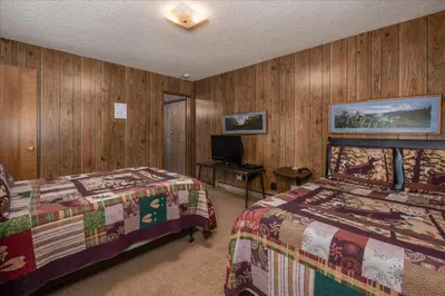 a bedroom with two beds and a television in it at PaPa Bear Cabin in North Wawona