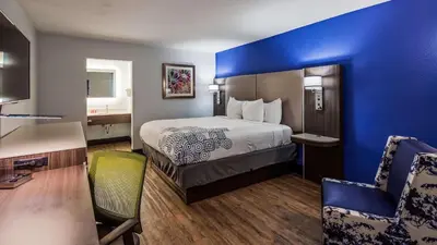 a hotel room with a bed with a blue wall at SureStay Plus Hotel by Best Western Sacramento Cal Expo in Sacramento