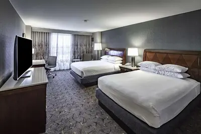 a hotel room with two beds and a flat screen tv at DoubleTree by Hilton Modesto in Modesto