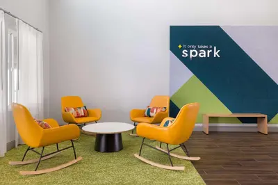 a waiting room with chairs and a table and a sign at Spark By Hilton Santa Nella in Santa Nella Village