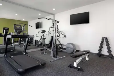 a gym with several exercise bikes and a flat screen tv at Spark By Hilton Santa Nella in Santa Nella Village