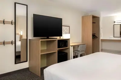 a hotel room with a bed and a flat screen tv at Spark By Hilton Santa Nella in Santa Nella Village