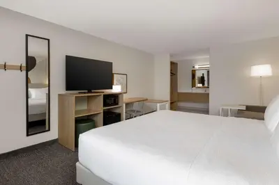 a hotel room with a bed and a flat screen tv at Spark By Hilton Santa Nella in Santa Nella Village