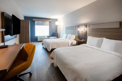 a hotel room with two beds and a flat screen tv at Holiday Inn Express & Suites Lathrop by IHG in Lathrop