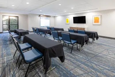 a conference room with tables and chairs and a tv at Holiday Inn Express & Suites Lathrop by IHG in Lathrop