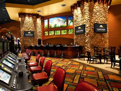 a bar in a casino with chairs and a table at Chukchansi Gold Resort & Casino in Coarsegold