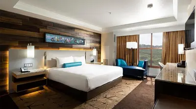 a hotel room with a bed and a desk and a chair at Chukchansi Gold Resort & Casino in Coarsegold